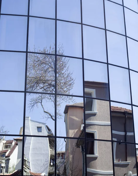 Reflexões de casas e árvores em um novo edifício de vidro — Fotografia de Stock