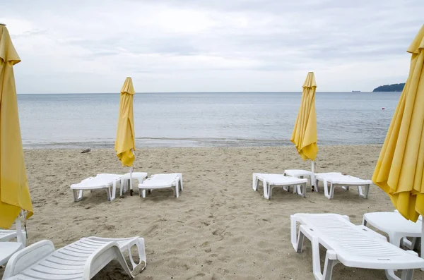 Paraplu's en plastic parasols op het strand in bewolkte dag — Stockfoto