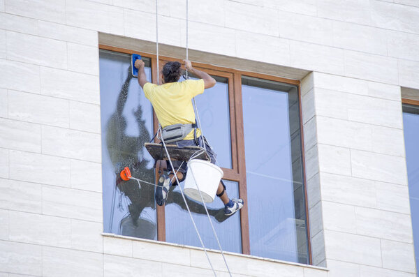 One window washer  hanging on rope 