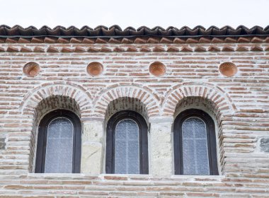 Üç küçük kemer windows bir tuğla duvar