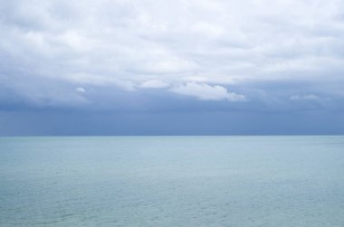 Turkuaz deniz su yüzeyi ile ufuk ve gökyüzü bulutlu