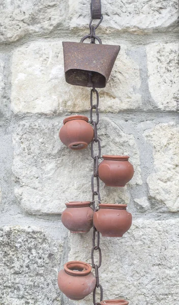 Um elemento decorativo de uma chaminé, potes cerâmicos e um chai enferrujado — Fotografia de Stock