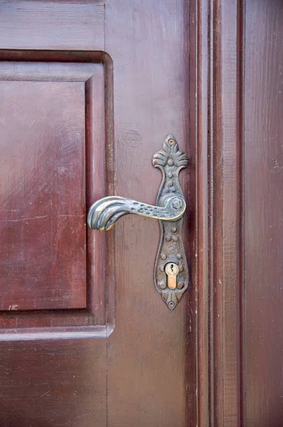Maniglia vecchia su porta marrone chiusa in legno — Foto Stock