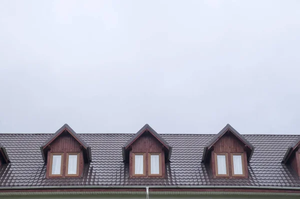 Trois lucarnes en bois avec fenêtres sur le nouveau toit en métal brun — Photo