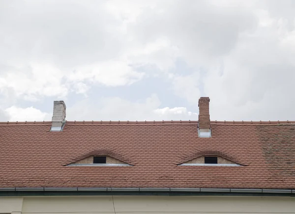 Zwei Gauben mit Fenstern auf repariertem braunen Keramikdach — Stockfoto