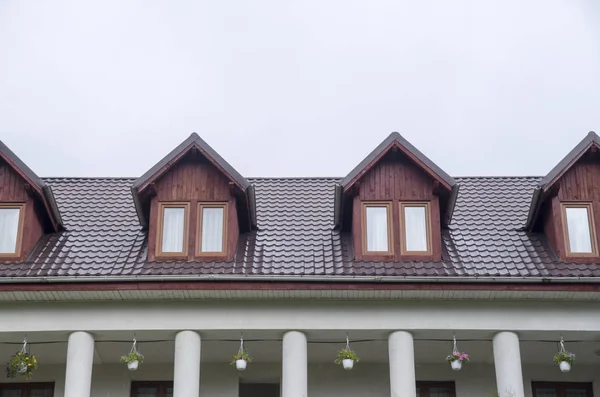 Several wooden dormers with windows on new brown metal roof — Stock Photo, Image