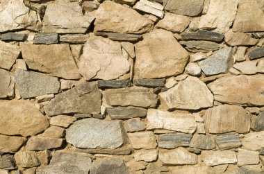 Güneşli bölgede eski renkli taş duvar kapanıyor.