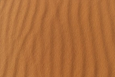 Kum dokusu - çöl kum tepelerinin arka planı. Kum tepelerinin güzel yapıları. Çölde rüzgardan gelen kumla - Yaklaş