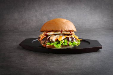 Sığır burger - Gri arka planda izole edilmiş sığır eti köftesi, turşu, peynir, domates, soğan, marul ve ketçap hardallı klasik peynirli burger