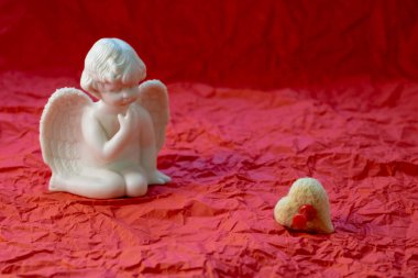 kalp ve üzgün melek kırmızı arka planda