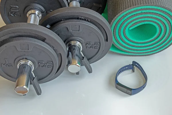 Bir çift dambıl ve spor için bir paspas.