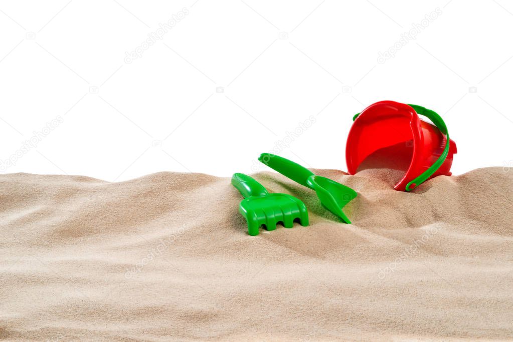 On the Beach - Sand dune with sand toys in front of a white background - clipping path included