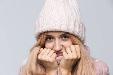 Çekici, utangaç, pembe kazaklı ve beyaz şapkalı bir kadının kamera / pozitif insan yüz ifadelerinden ve duygularından tatmin olan stüdyo portresini kapat. Mükemmel cilt / insan konsepti.. 