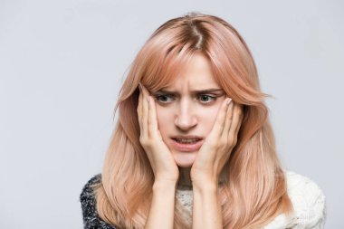 Close up studio portrait of terrified girl in white sweater, gnawing nails, looking aside/found out what happened, bad news, nervous feeling, experiences of fear/ problem, nervous, people concept.