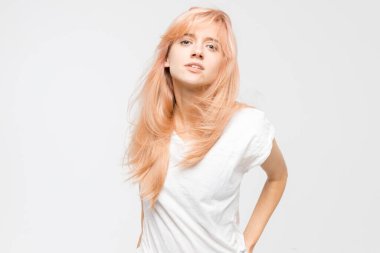 Beyaz tişörtlü, kibirli sarışın kızın stüdyo portresini kapat. Kadın kameraya kibirli bakıyor. Canı sıkkın, kızgın ve sinirli bir kadın. Duygular konsepti. Boşluğu kopyala.