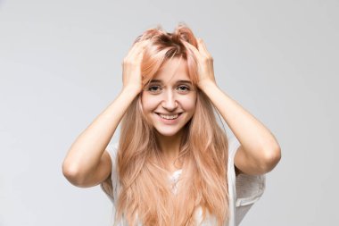 Cropped studio portrait of cute student in white t-shirt looking at camera and attractive smile, holds hands on the head/good-looking, cheerful lady, satisfaction, people, beauty and lifestyle concept