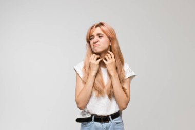 Beyaz tişörtlü, boynu kaşınan, tahriş olan, hassas cilt, alerji belirtileri, burun iltihabı, soğuk, kaşıntı, sağlık ve tıp konsepti olan güzel bir kadının izole edilmiş stüdyo portresi..