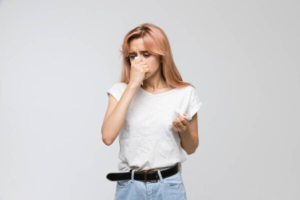 Портрет милой молодой красивой женщины, сморкающейся в бумажную салфетку / холод, чихание, симптомы аллергии, грипп, ринит, болезнь, отчаянно больная, концепция здравоохранения и медицины / копировальное пространство
.