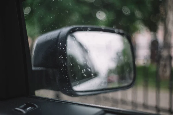 近照雨滴落在挡风玻璃上 有选择性的焦点模糊的背景汽车工业 后视镜中的反光 多雨的季节车内的舒适 — 图库照片