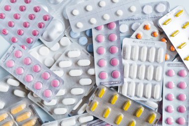Çeşitli ilaçlar: farklı ilaç hapları, grip ve akan burun için bir ilaç, baş ağrısı hapları, antibiyotikler. Tıbbi ve sağlık hizmetleri konsepti. Düz konum, üst görünüm, kırpılmış fotoğraf.
