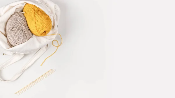 繊維袋に糸の黄色とベージュの爪 糸の黄色の肌から糸が竹編み針に実行されます コピースペース 針仕事とレジャーの概念 デザインのテンプレート — ストック写真
