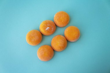 Mangolu Mochi. Pirinç hamuruna sarılı birinci sınıf dondurma, geleneksel Japon çölü. Glütensiz. Pasta mavisi üzerine turuncu