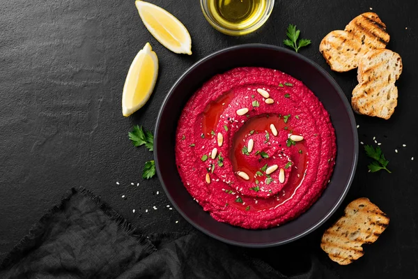 Baked Beet Hummus Met Geroosterd Brood Een Zwarte Keramische Kom — Stockfoto