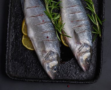 Siyah tavada limonla doğranmış taze levrek.