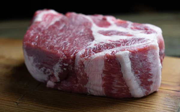 pork cut from the neck on a wooden board