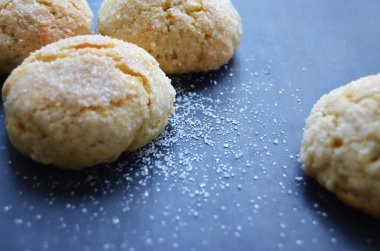 Siyah arkaplanda şeker serpiştirilmiş kurabiyeler