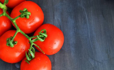 Eski ahşap arka planda kırmızı domatesler.