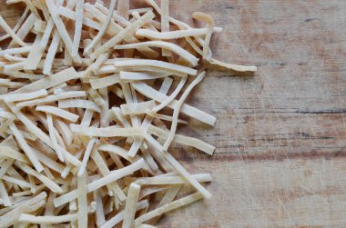 Tahta yüzeye serpiştirilmiş ev yapımı makarna.