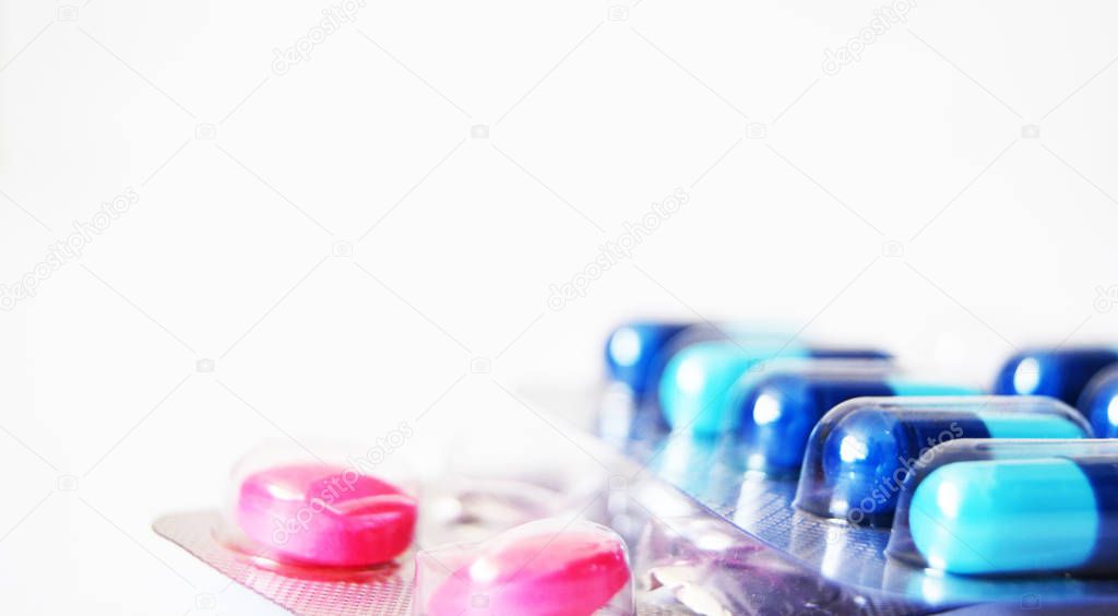 Pills and medicine capsules in white space.