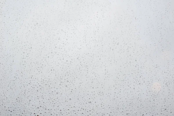 Regentropfen auf Fensterglas mit bewölktem Himmel als Hintergrund — Stockfoto
