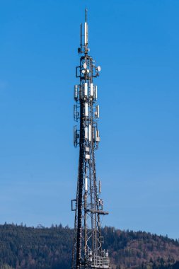 Arkaplan olarak mavi gökyüzüne karşı hücresel ağ antenli Telekomünikasyon kulesinin fotoğrafı 