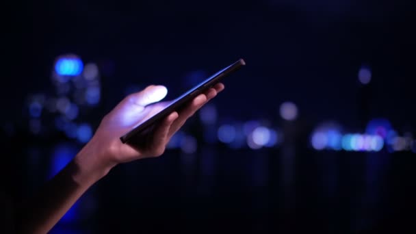 Smartphone gebruiken in de stadsavond — Stockvideo