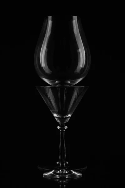 Due bicchieri di vino vuoti posti uno di fronte all'altro su uno sfondo nero / — Foto Stock