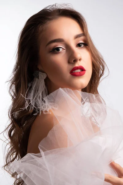 Cierre el retrato. Joven chica hermosa con el pelo largo rizado y maquillaje perfecto en vestido de velo blanco. Captura de estudio . —  Fotos de Stock