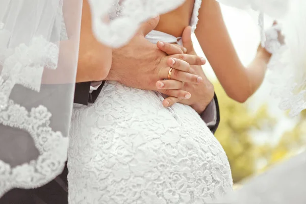 Le mani degli sposi su uno sfondo sfocato — Foto Stock