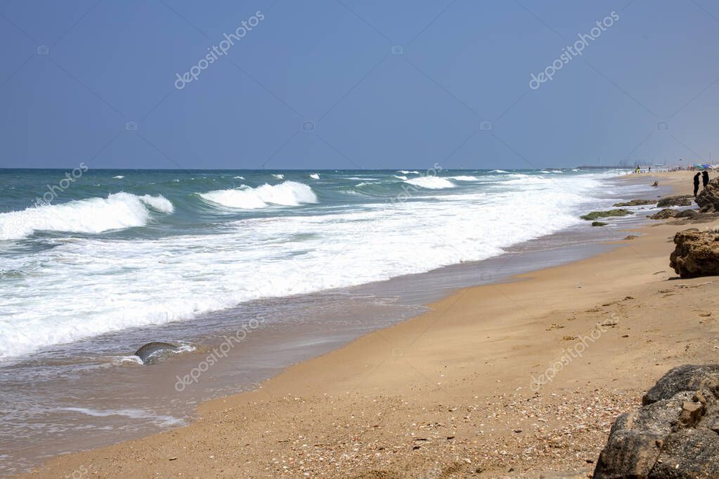 Sea beach with stone formations and incident foam waves on the shore of Ashkelon National Park