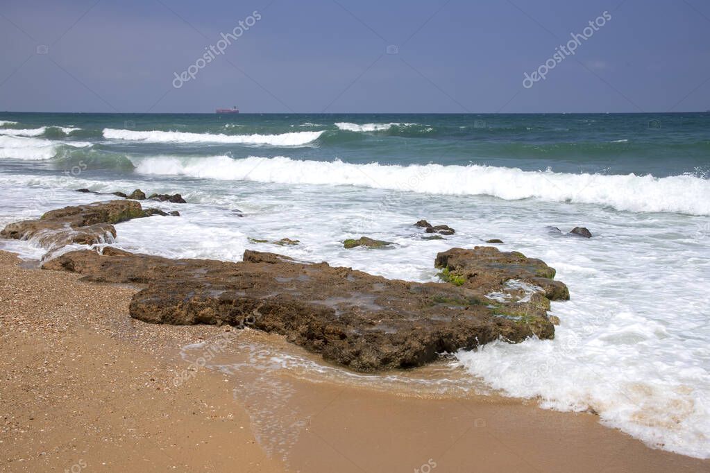 Sea waves crashing on stone formations on the shore of Ashkelon National Park