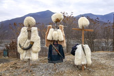 National clothes of Georgian shepherds burka and papakha against mountains clipart