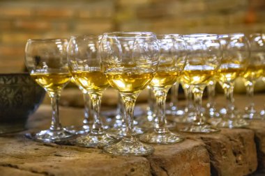 Kehribar şarabı ile doldurulmuş şeffaf cam kadehler.