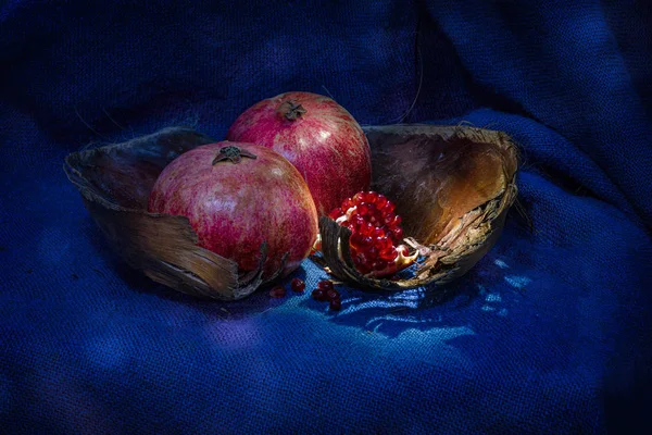 Fruits et graines de grenade dans un panier en bois sur toile de jute avec éclairage bokeh — Photo