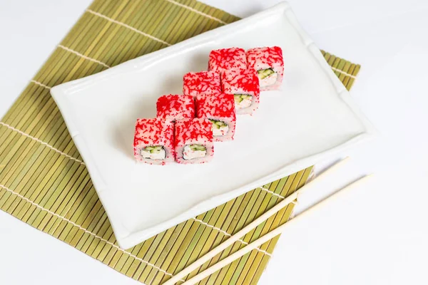 Sushi-Rolle auf Teller und Rollmatte — Stockfoto