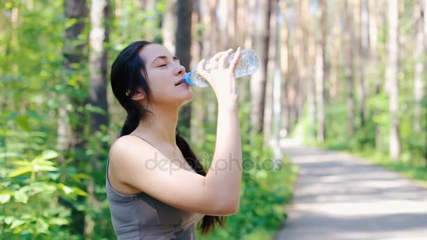 Το κορίτσι τον εαυτό της ποτίζονται με νερό από ένα μπουκάλι — Αρχείο Βίντεο