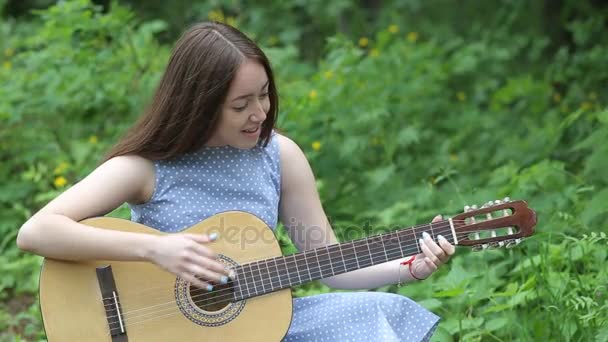 Красивая девушка играет на гитаре — стоковое видео