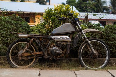 Eski kirli motosiklet sokakta kaldı.