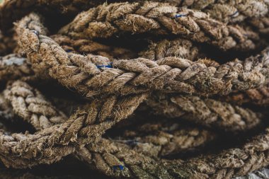Kumsalda bükülmüş eski kahverengi deniz ipi