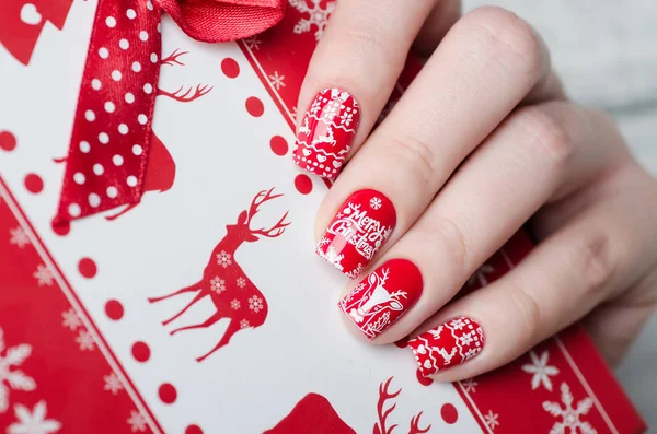 Czerwony świąteczny manicure z jeleniem i płatkami śniegu — Zdjęcie stockowe